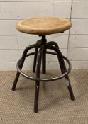 An industrial style wooden topped adjustable stool