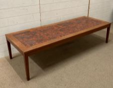 A teak Mid Century style coffee table with red tiled top (H40cm W170cm D63cm)