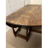 A drop leaf gate leg oak table (H70cm W152cm D136cm)