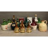 A selection of ceramic spirts flagons and decanters too include bells bells and Tllamare Dew