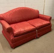 A red upholstered two seater sofa bed