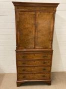 A walnut veneered four drawer drinks cabinet with pull out serving tray (H152cm W72cm D43cm)