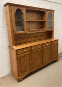 A Ducal pine four drawer cupboard Welsh dresser with glazed cupboard above