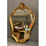 A wooden framed gold painted wall mirror