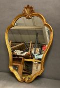 A wooden framed gold painted wall mirror