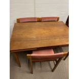 A Danish table and chairs, teak table with pull out leaves on tapering legs and six Mid Century