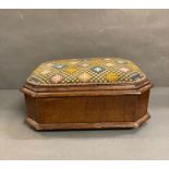 A cross stitch mahogany foot stool on bun feet with hinged lid