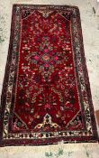 A hand knotted Iranian carpet/rug (220cm x 104cm)