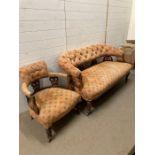 A Victorian mahogany button back arm chair and sofa on castors