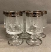 Five hand blown and etched wine glasses with etched metallic rims