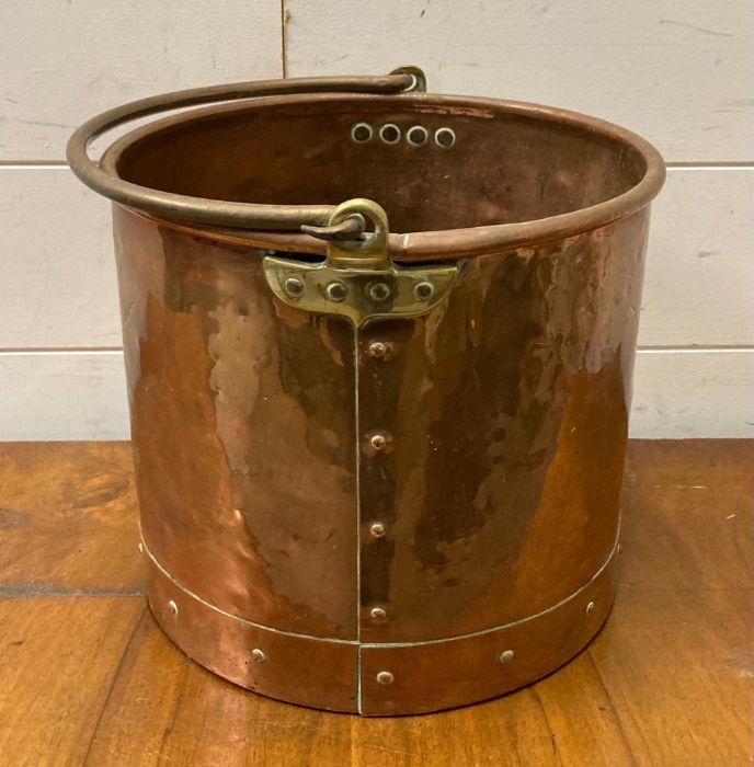 A swing handled copper and brass log bucket
