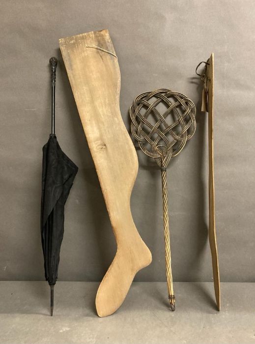 A vintage umbrella, a carpet beater and two wooden decorative legs