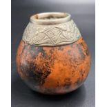 A gourd with white metal top