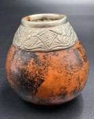 A gourd with white metal top