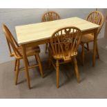 A Mid Century pine table and four wheel back chairs (H76cm W122cm D68cm)