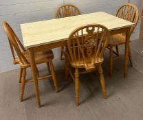A Mid Century pine table and four wheel back chairs (H76cm W122cm D68cm)