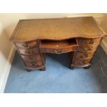 A leather top desk with serpentine front on bracket feet (H78cm W116cm D55cm)