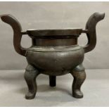 A Chinese incense bronze burner. A tripod censer raised on three feet and S -shaped handles (H25cm