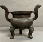 A Chinese incense bronze burner. A tripod censer raised on three feet and S -shaped handles (H25cm