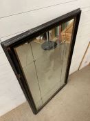A panelled wall mirror with brass studs in a black and gilt frame (80cm x 130cm0