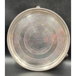 A Victorian silver salver on three feet, engraved, approximately 23.5cm in diameter and 515g in