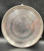 A Victorian silver salver on three feet, engraved, approximately 23.5cm in diameter and 515g in