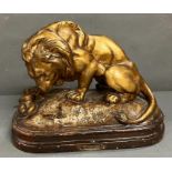 A metal sculpture of prowling lion on a plinth (H28cm W35cm)