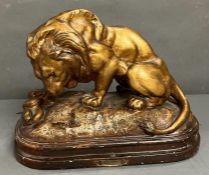 A metal sculpture of prowling lion on a plinth (H28cm W35cm)