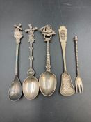 A small selection of four silver spoons and a fork.
