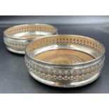 A pair of hallmarked silver wine coasters by D J Silver Repairs, hallmarked for London 1968
