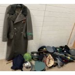 A large selection of reproduction military items including German border coat and USSR caps and hats