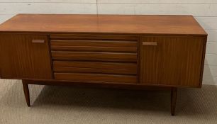A Mid Century teak side board with drawers to centre and flanked by cupboards (H77cm W168cm D46cm)
