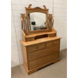 An antique pine dressing table with mirrored top with S shaped supports terminating with drawers