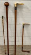 Four hunting and walking sticks, two with silver collars and one with a military crest