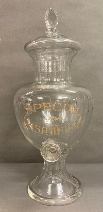 A large glass special Irish whisky dispenser/decanter with faceted lid on a flared circular foot (
