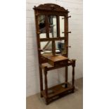 A carved hall stand with turned wooden hooks and mirror plate (H200cm W78cm D37cm)