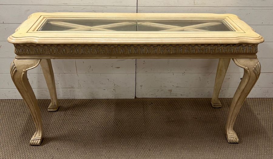 A French style console table with glass top and shell detail to legs (H73cm W130cm D46cm)