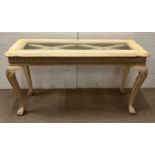 A French style console table with glass top and shell detail to legs (H73cm W130cm D46cm)