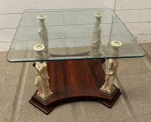 A glass top table with statue supports to each corner (H42cm SQ66cm)