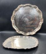 Two silver plated trays both with scalloped edges and the largest 35cm across.