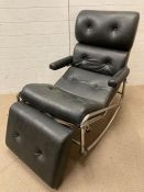 A black leatherette rocking chair with leg cushion in the style of Lama