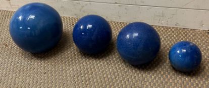 Four blue garden spheres or balls