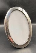 An oval hallmarked silver picture frame, approx 21.5 cm high with an easel back. Birmingham 1921.