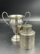 A hallmarked silver small trophy and a lidded canister