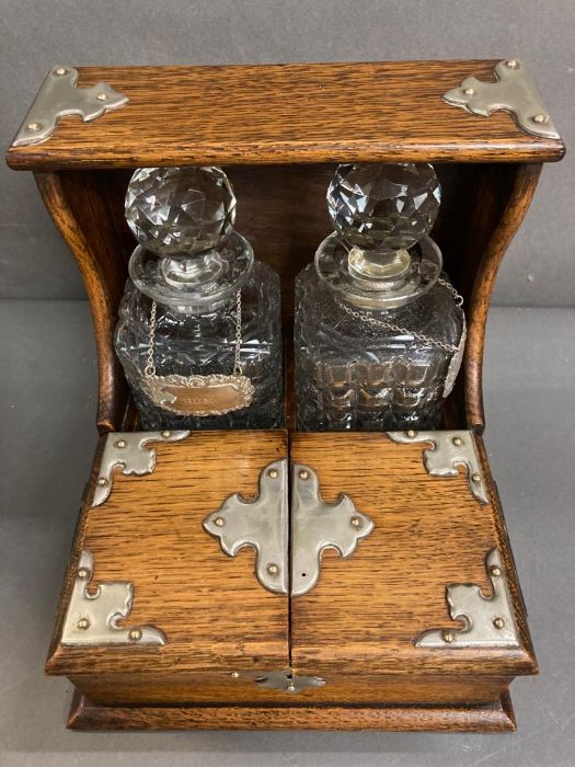 An oak two decanter tantalus with double hinged lids to front to reveal a partitioned storage - Image 5 of 5