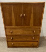 A light oak mid century cupboard with three drawers under (H104cm W77cm D41cm)