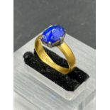 A 22ct golf ring with central blue stone.(Approximate Total Weight 3.8g)