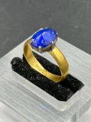 A 22ct golf ring with central blue stone.(Approximate Total Weight 3.8g)