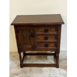An oak side cabinet on legs with carving to front (H69cm W60cm D32cm)