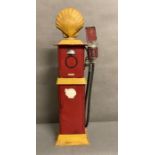 A metal painted model of a vintage shell petrol pump